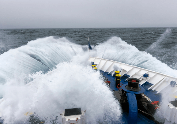 Hohe Wellen schlagen über den Bug des Kreuzfahrtschiffs bei der Druchquerung der Dänemarkpassage